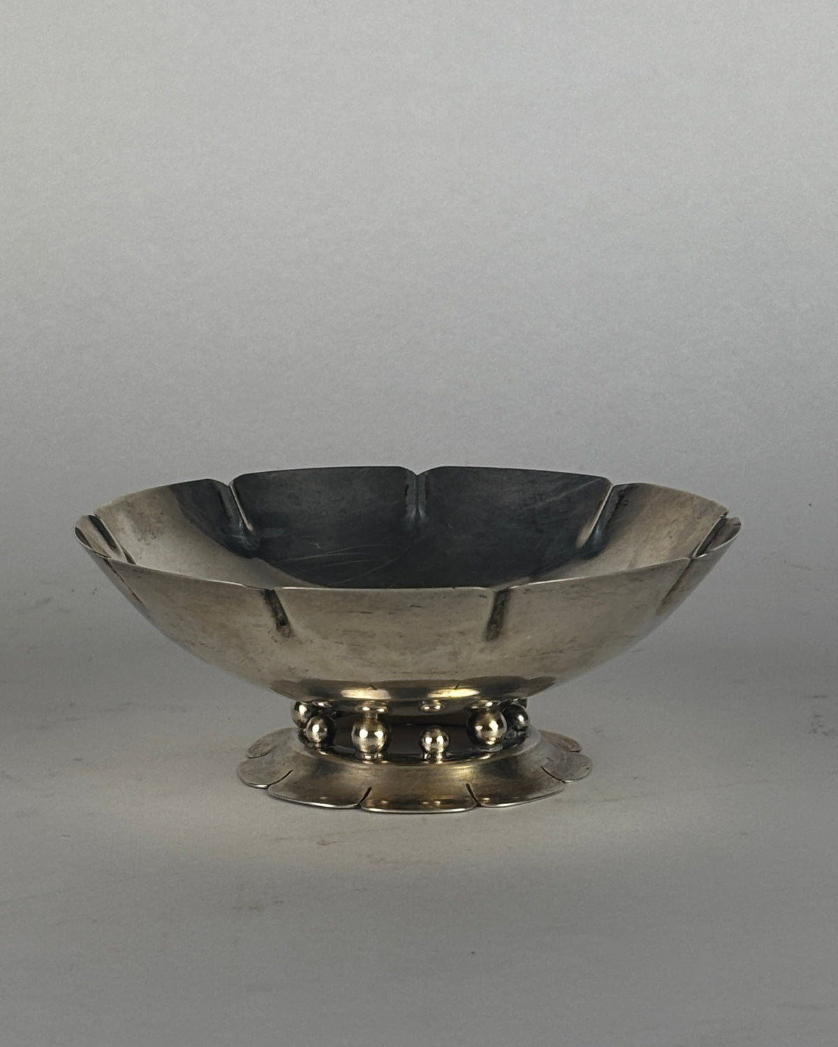 Sterling silver footed bowl with scalloped rim and decorative base