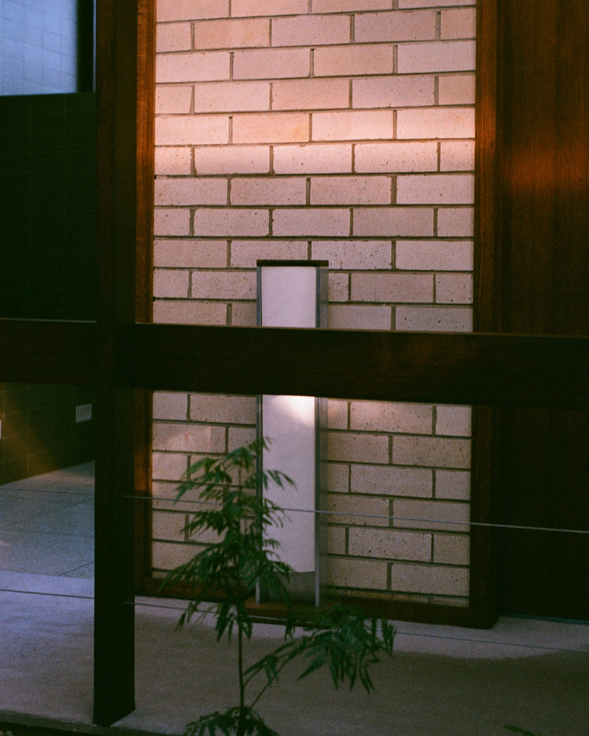 Aluminium Floor Lamp — side view against textured brick wall