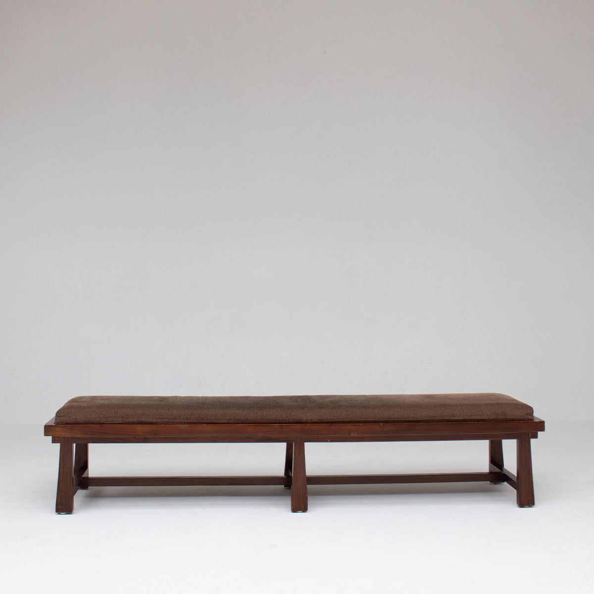 Rustique Bench in Wood with Cushion — side angle showing dark wood frame