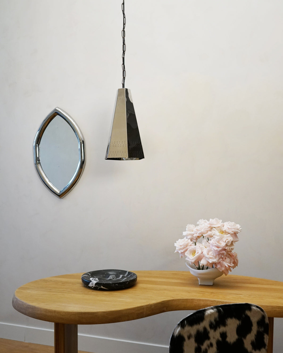 Bowie Ceiling Lamp - Polished Steel — side angle above wooden table with decor