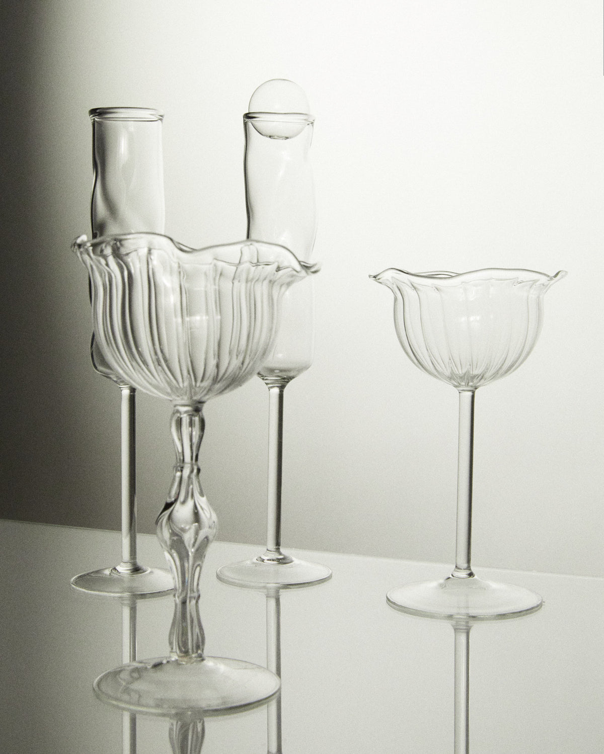 Clear glass champagne coupes with ribbed bowls in elegant arrangement