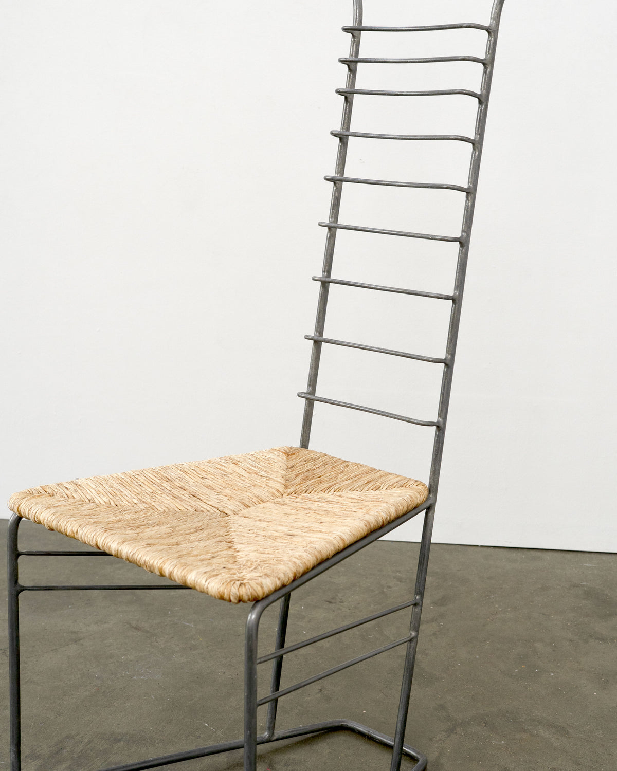 Vintage sculptural steel chair with woven straw seat, high ladder back