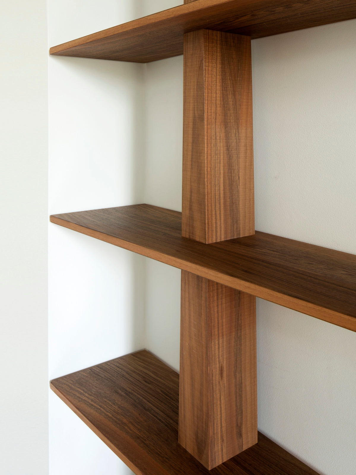 Greg Bookcase — side angle showing walnut shelves and support