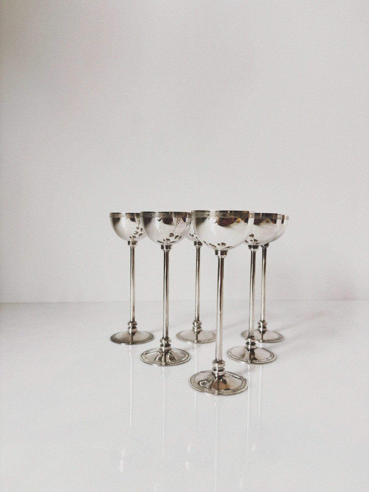 Set of six silver-rimmed champagne coupes with metallic stems