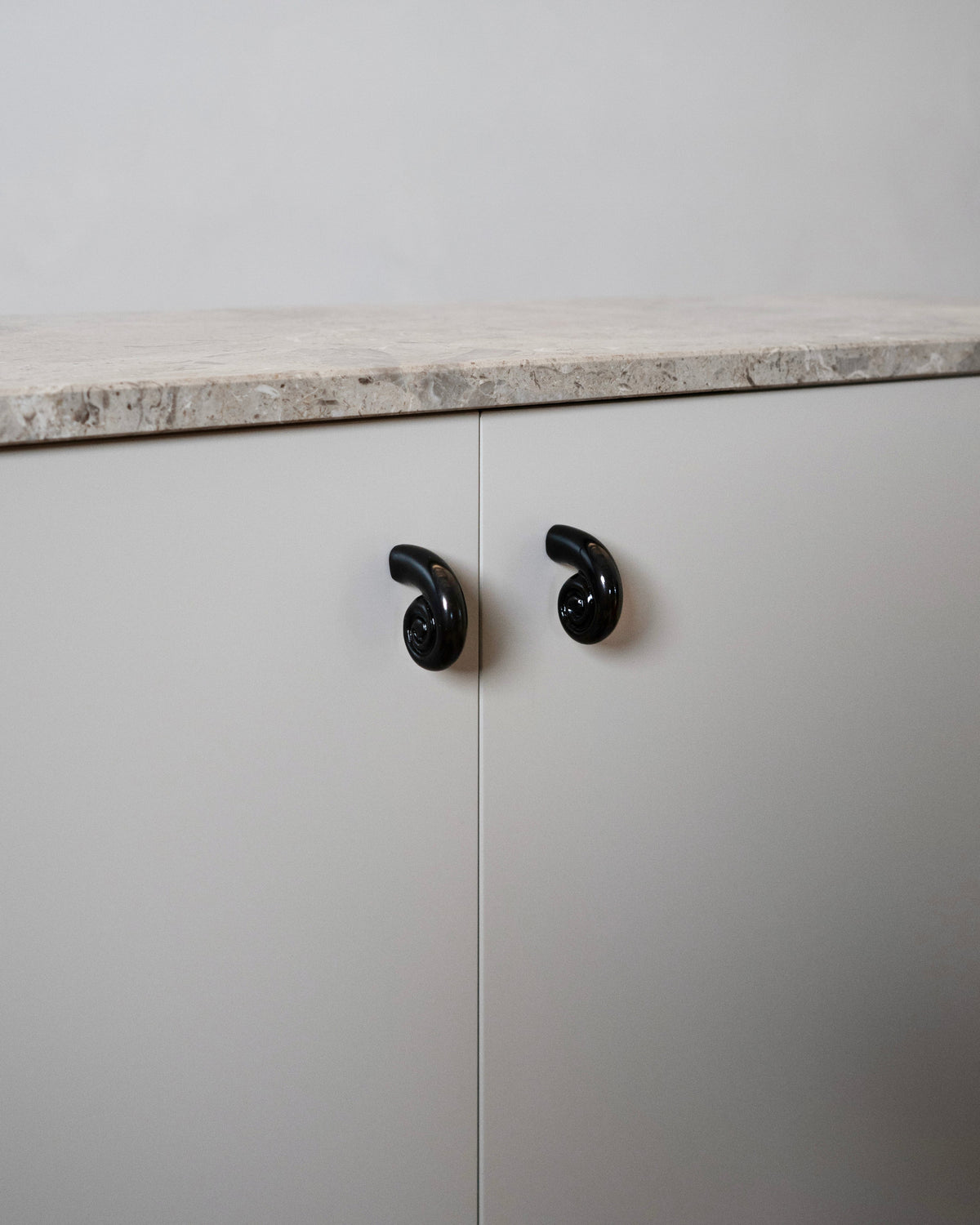 Noelle Knob - Antique Brass — installed on modern cabinet with stone top