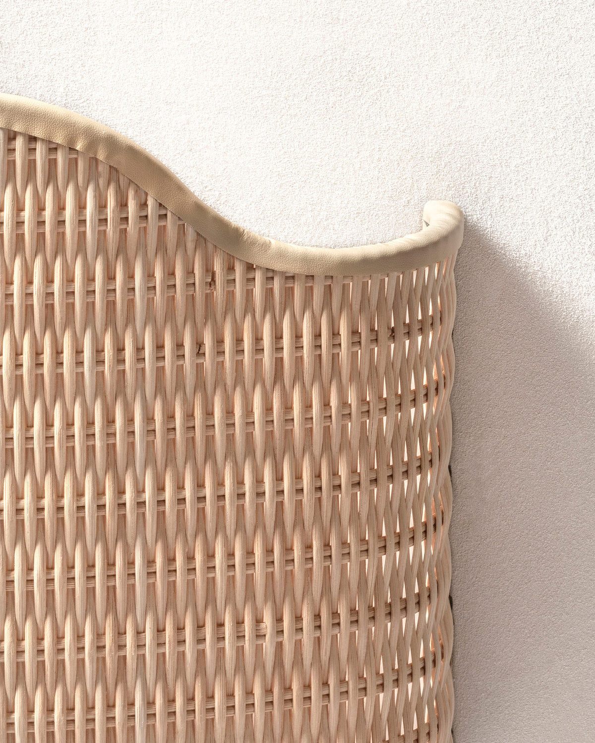 Detailed view of woven rattan wall light with leather trim