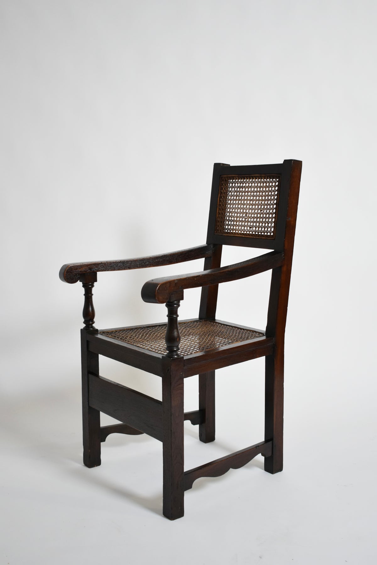 Pair of turned wood and cane armchairs, 1910s — side view highlighting cane seat and wooden frame