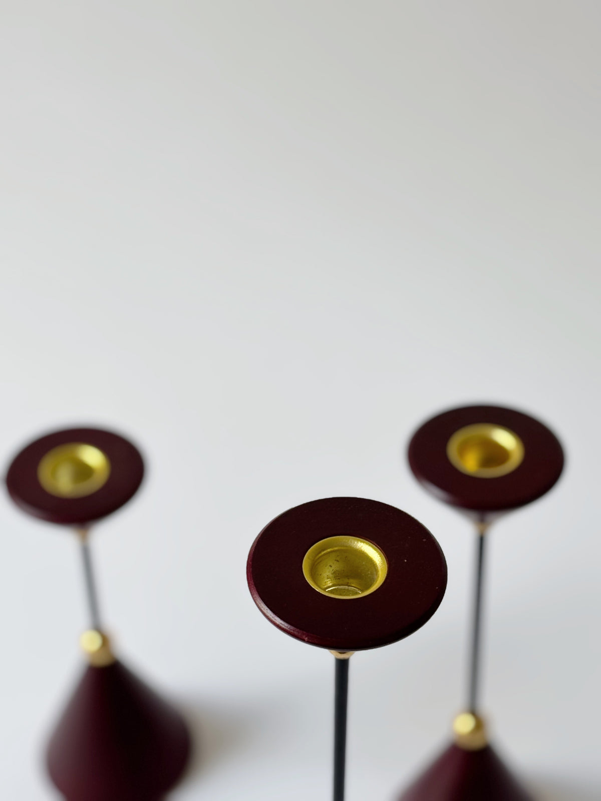 Set of Postmodern Candle Holders in Wood and Metal — overhead view of burgundy bases