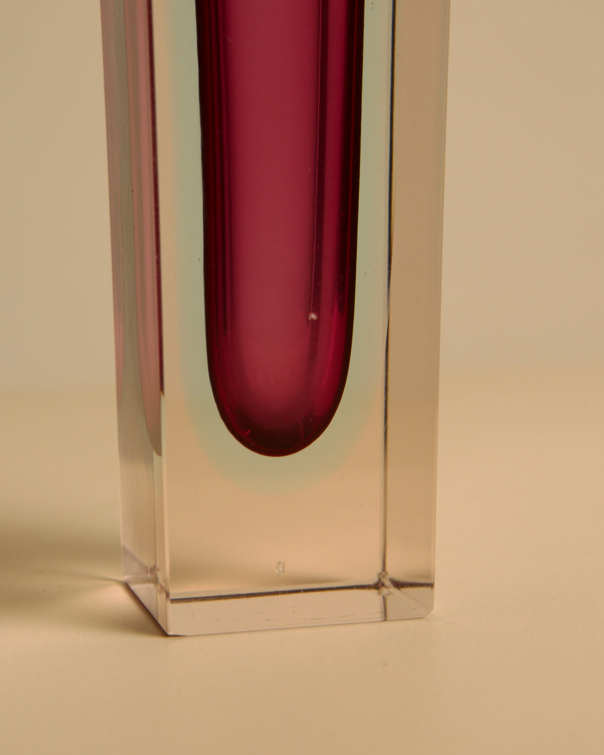 Close-up detail of red Murano glass vase showing clear crystal base