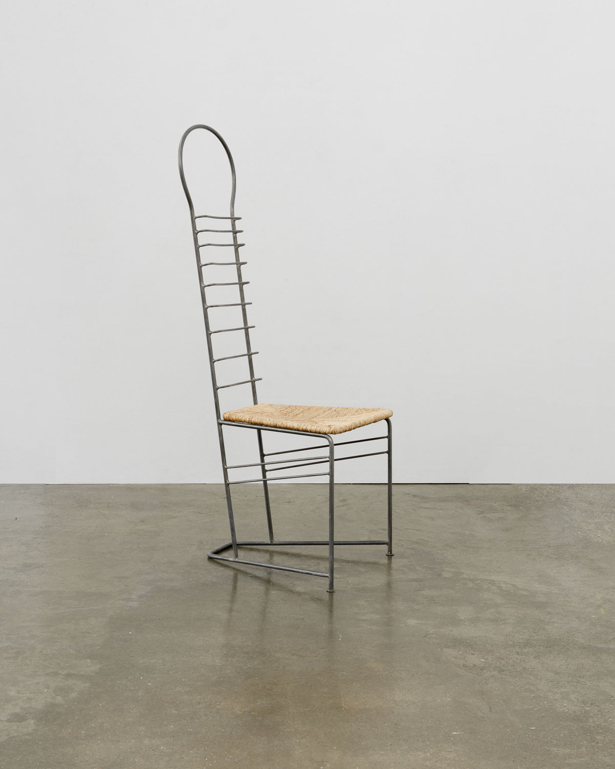 Vintage sculptural steel chair with woven straw seat and tall ladder back
