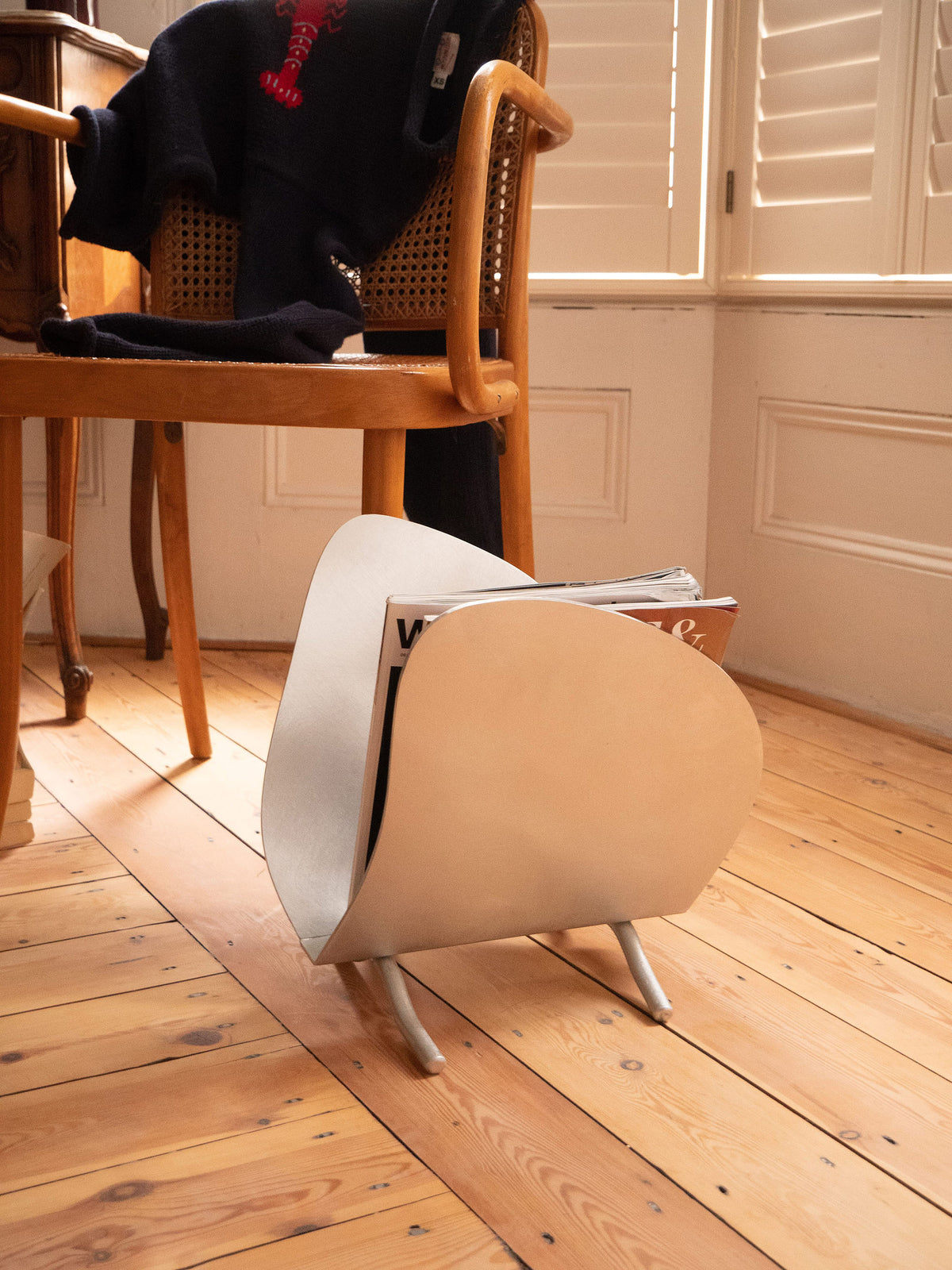 Magazine Rack — side view on wooden floor with magazines inside