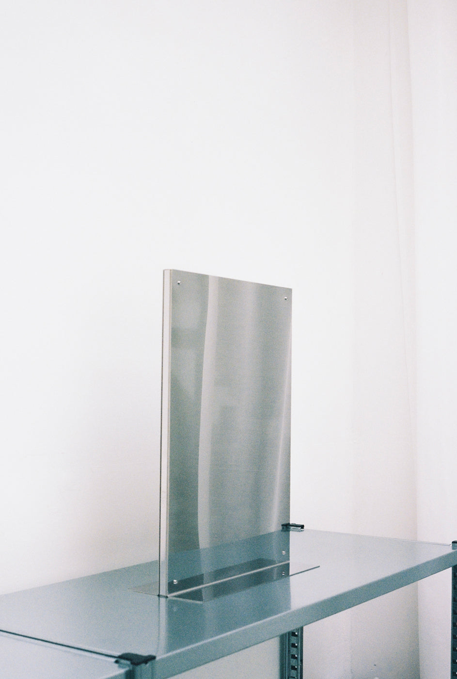 Clear acrylic desk divider on minimalist glass table