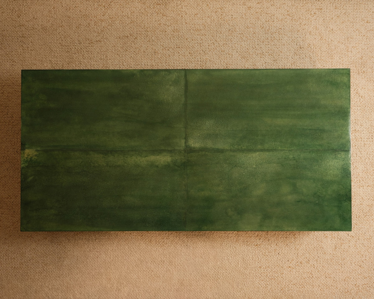 The Galerie Vauvart Green Parchment Table features a rectangular, dark green textured surface atop a beige, lightly speckled background, shown in an overhead view.
