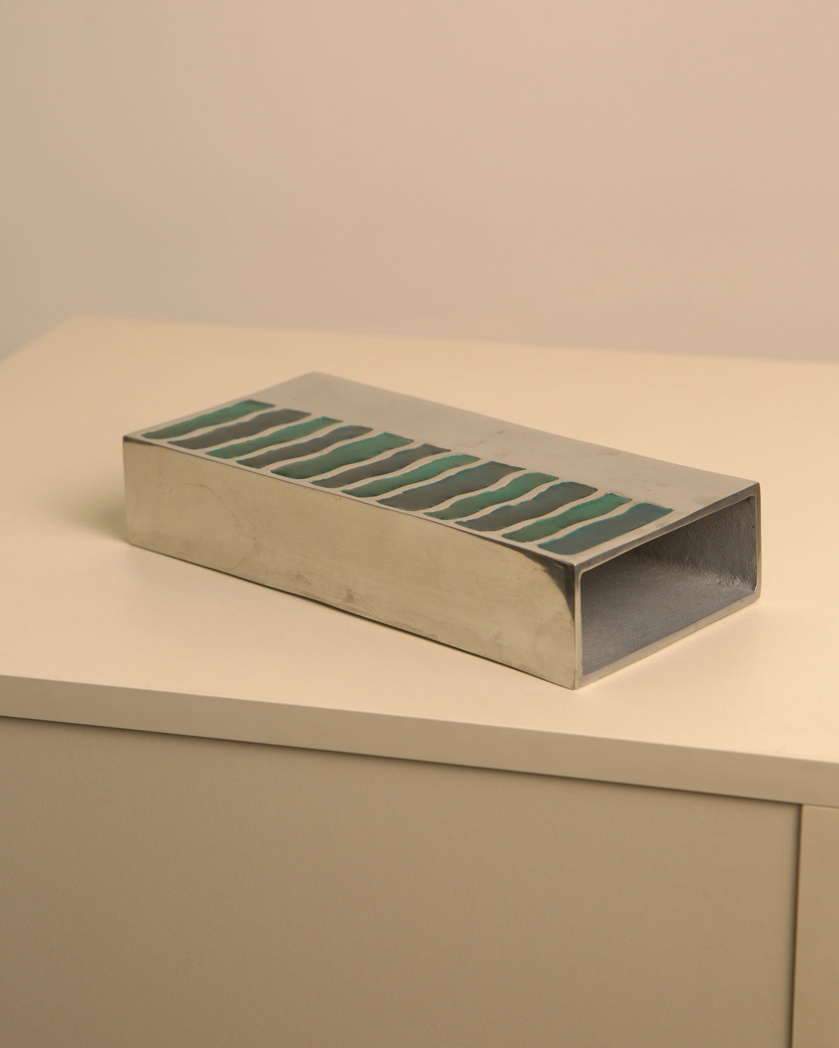 Green enameled aluminum vase detail showing striped pattern design