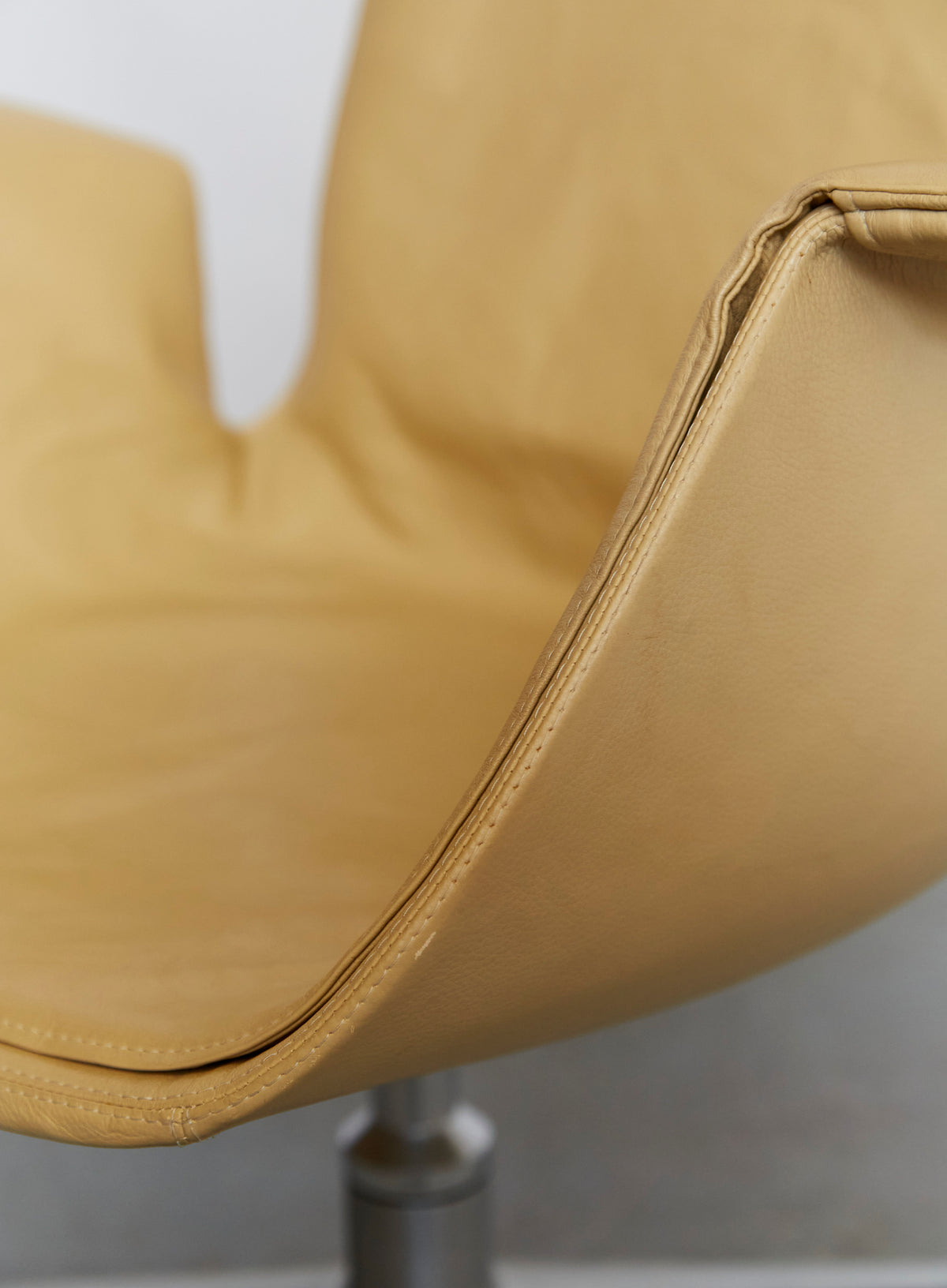 Close-up of mustard leather armrest and curved edge detail