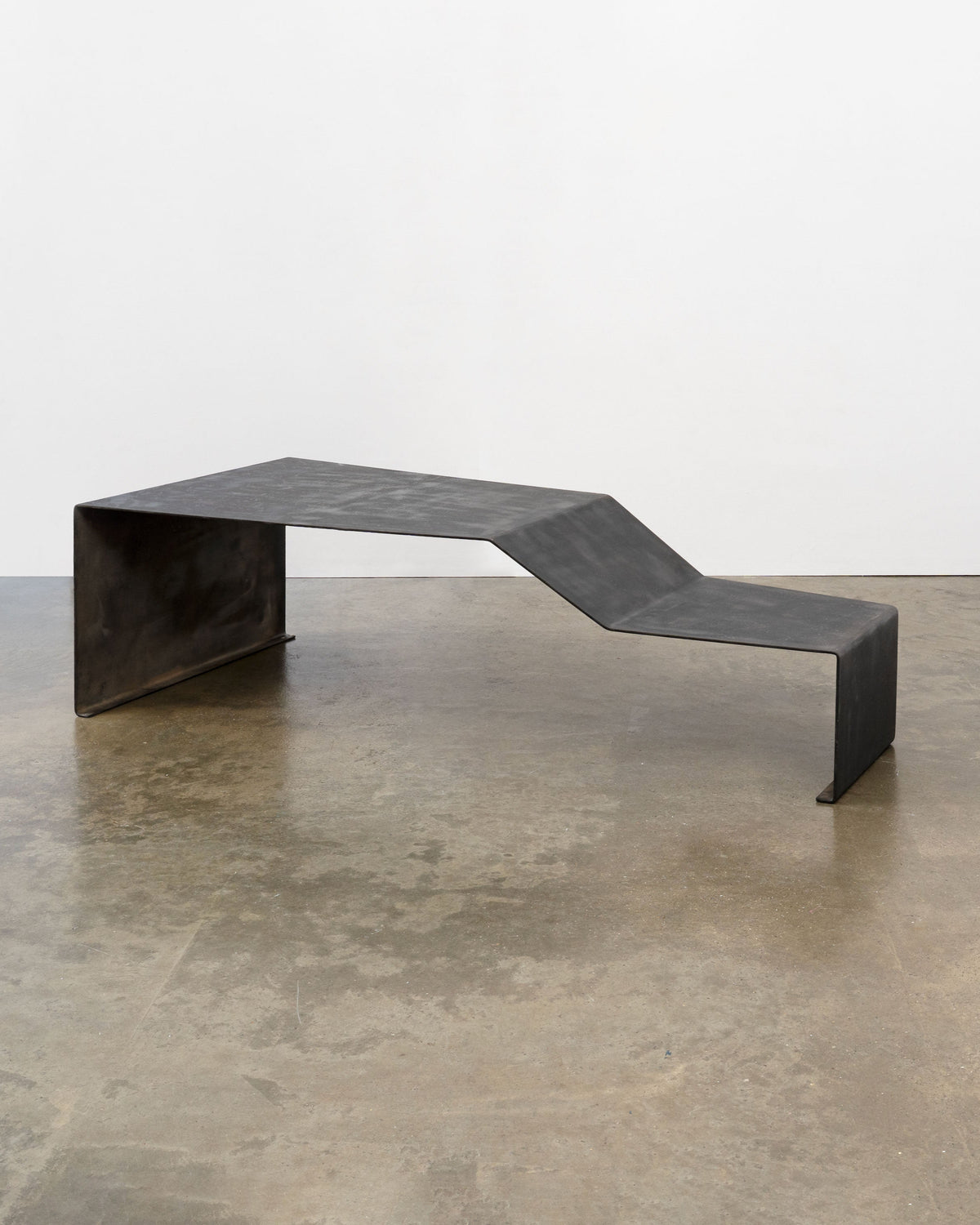 Large patinated steel bench coffee table with curved design