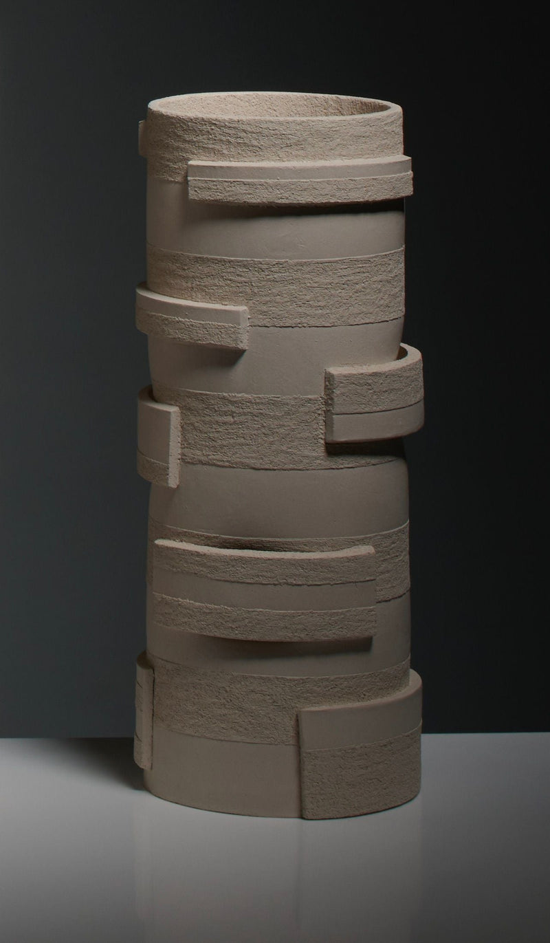 The "Bricks" Table Lamps in Ceramic by Katia Langeard feature a modern, geometric design with textured bands and rectangular accents in neutral beige—ideal as a stylish accent against a dark background.
