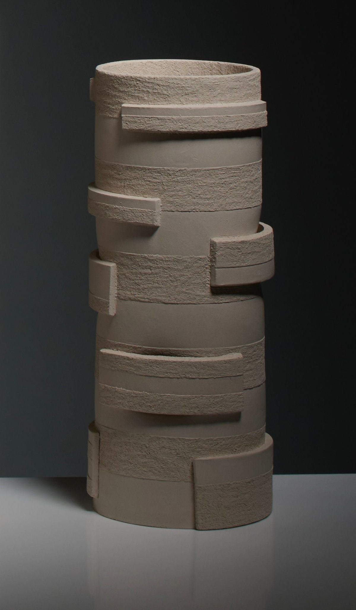The "Bricks" Table Lamps in Ceramic by Katia Langeard feature a modern, geometric design with textured bands and rectangular accents in neutral beige—ideal as a stylish accent against a dark background.