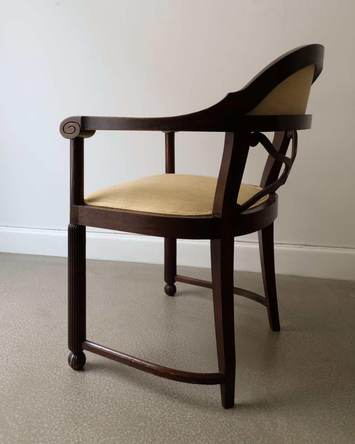 French Art Deco armchair profile view showing curved backrest and beige upholstery