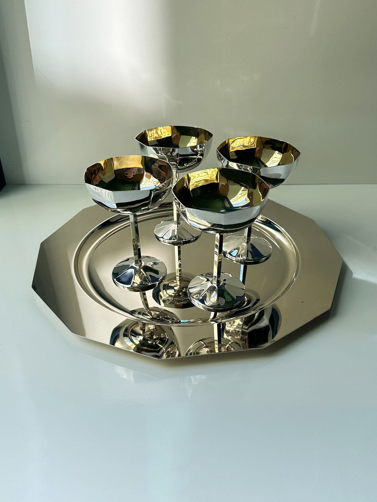 Four Art Deco silver-plated champagne coupes on matching tray