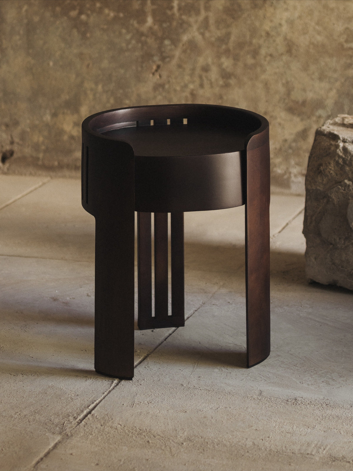 Dark wood cylindrical nightstand with geometric cutout details