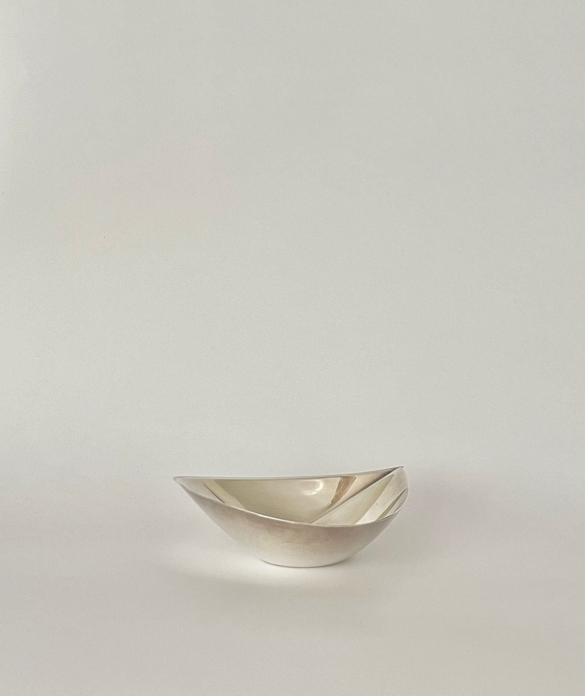 Tapio Wirkkala Silver Bowl 1957 — side angle on neutral background