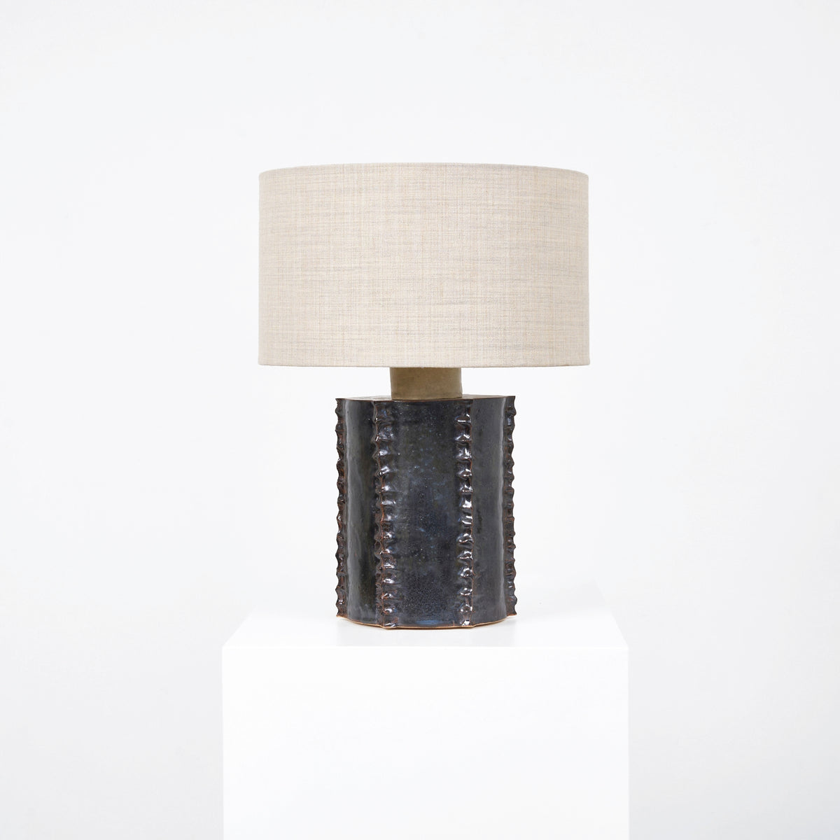 Totem Table Light — front view on white pedestal with linen shade