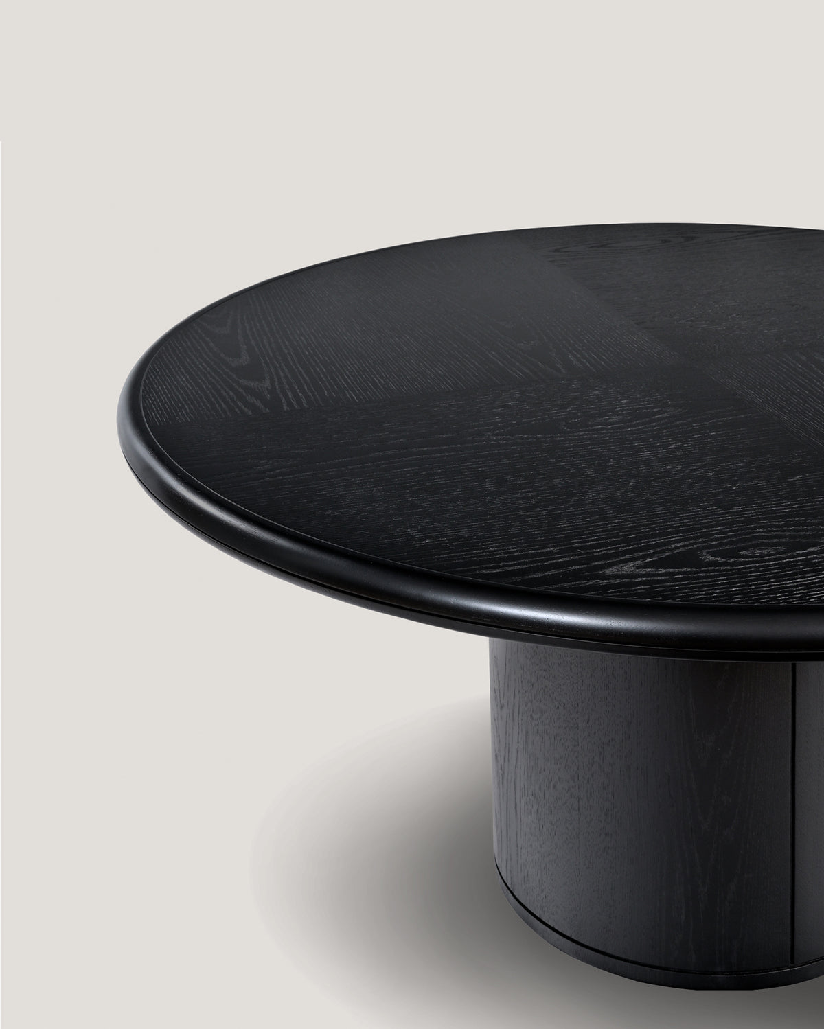 Close-up detail of Moon round dining table's black wood surface