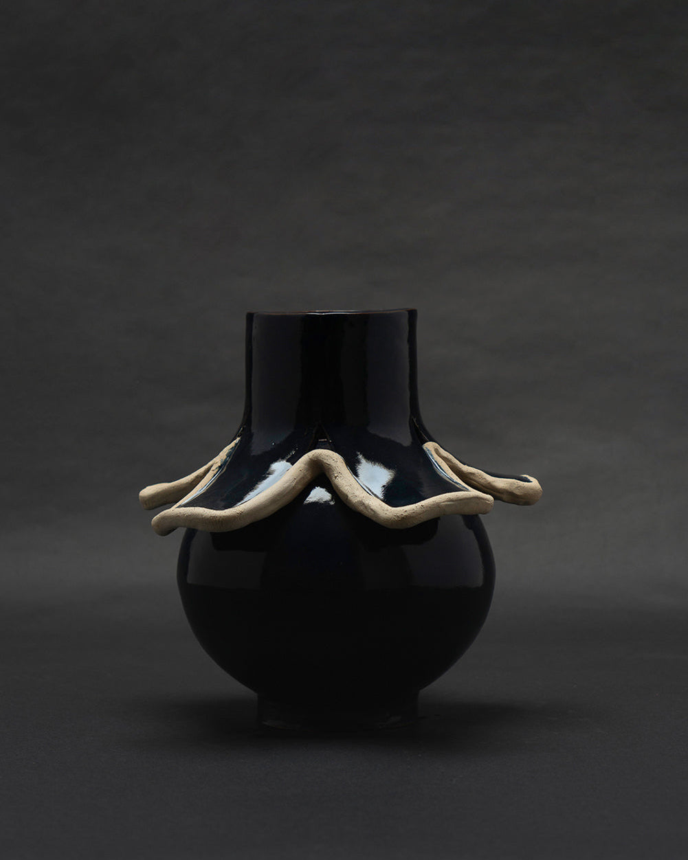 Navy blue glazed ceramic vase with undulating raw clay collar