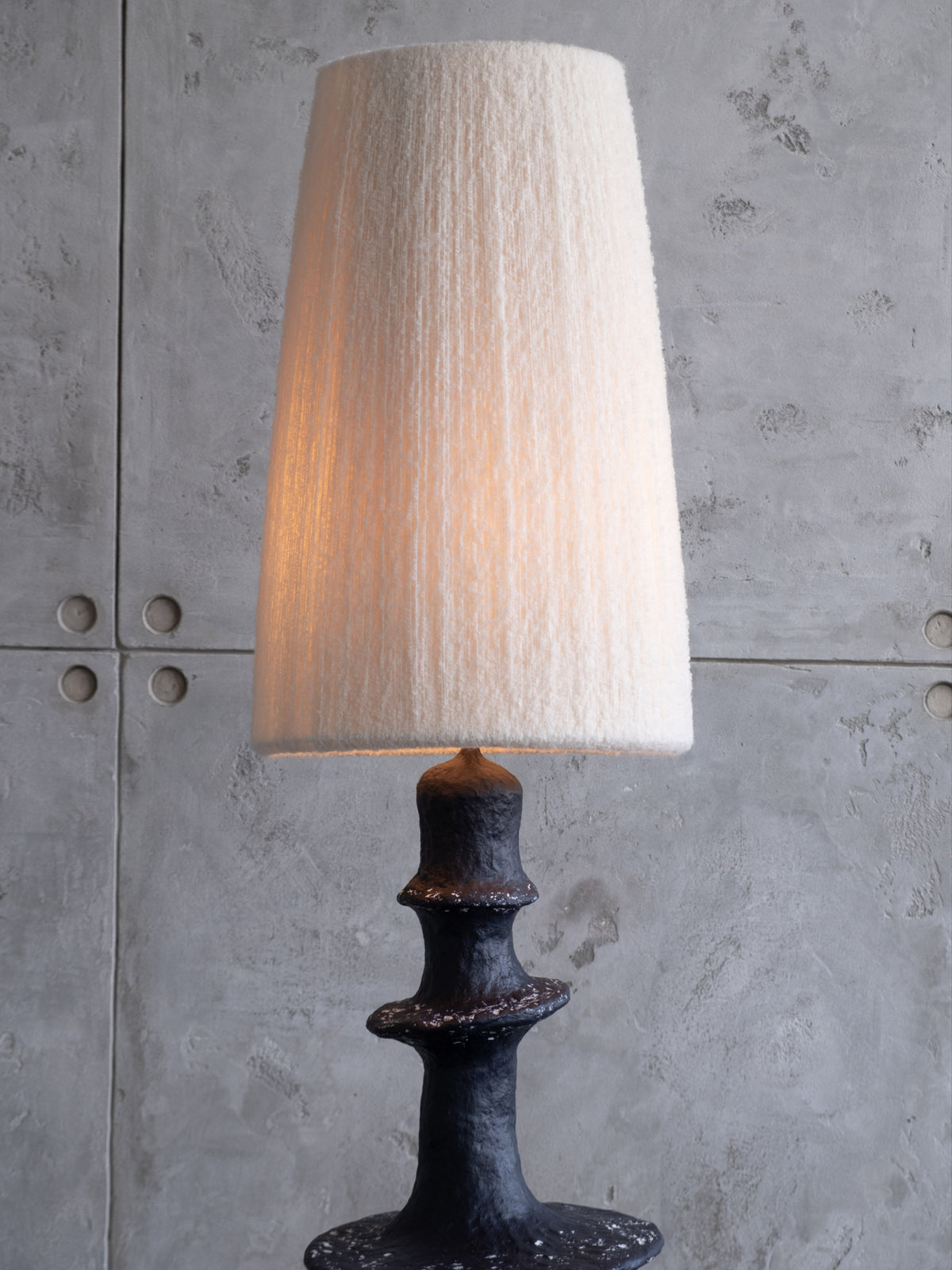 Orbita Floor Lamp — close-up of textured black base with cream shade