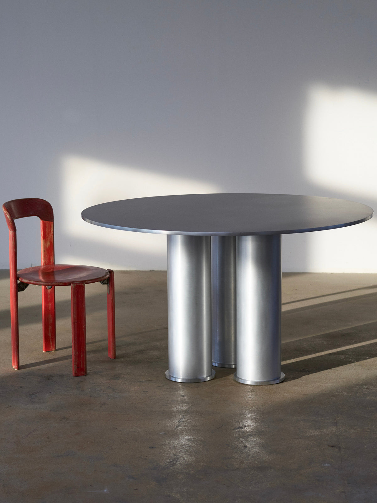 Elephant Table (Dining) — round metal table with red wooden chair
