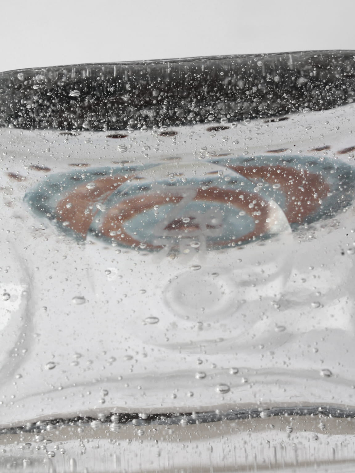 Vintage bubble glass carafe submerged in carbonated water detail