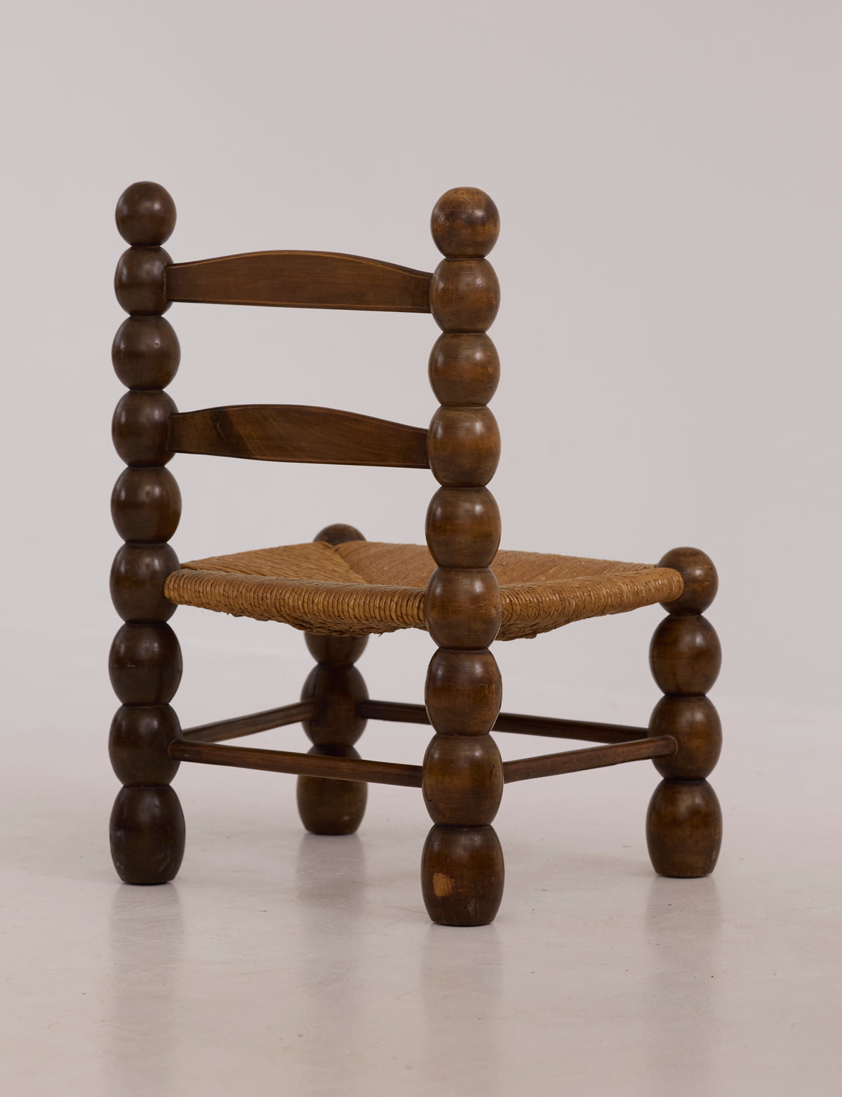 Vintage French Oak Wood and Straw Low Chair C. 1940 — angled view highlighting round wooden legs