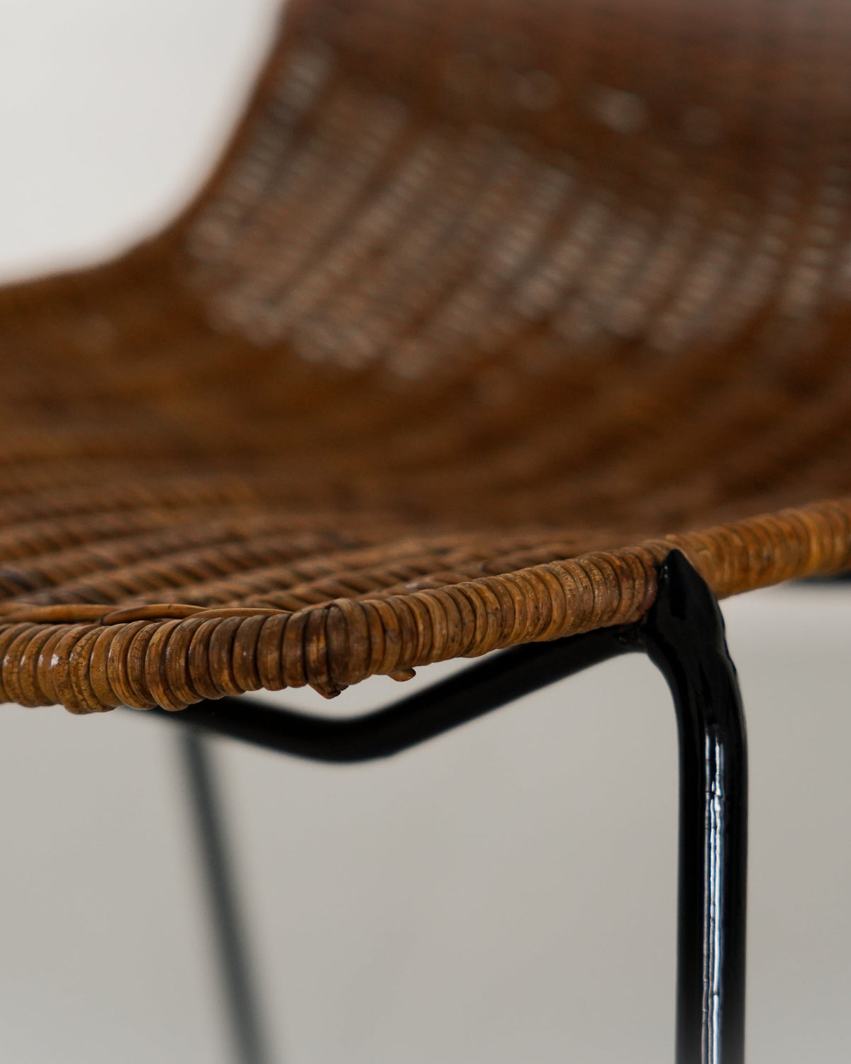 Rattan weaving detail on black metal frame of Basket Chair