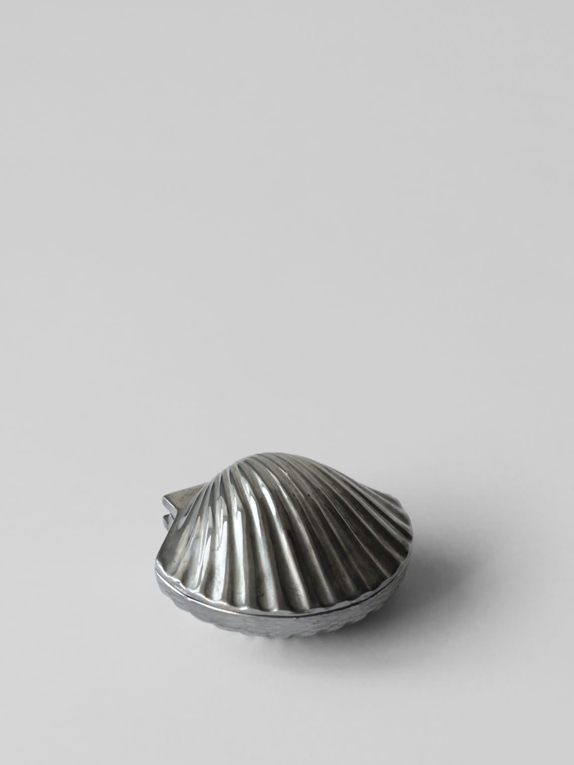 Silver plated shell-shaped pill box with ribbed surface detail