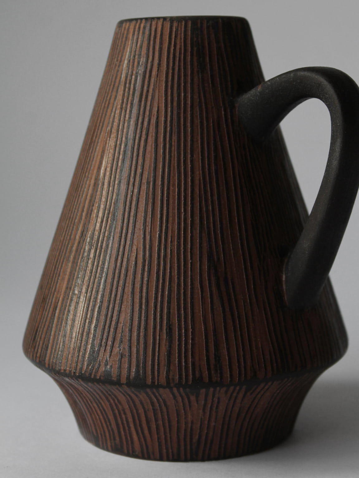 Vertical ridged ceramic jug profile showing teak wood texture