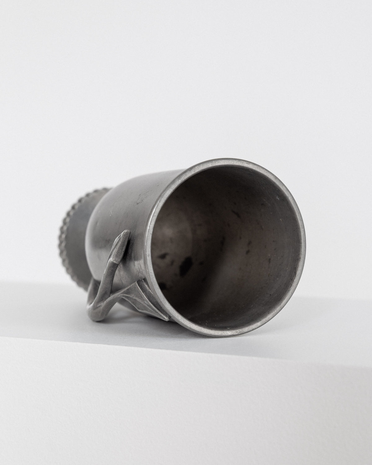 Interior view of elegant Swedish pewter vase showing crafted handle