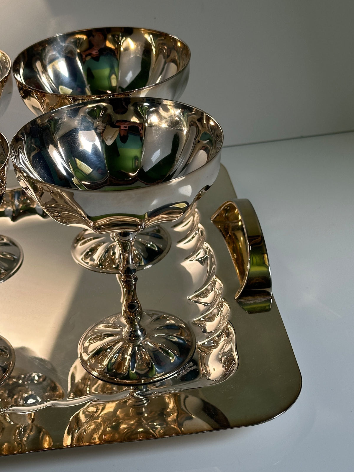 Reflective silver champagne coupes showing mirror finish detail