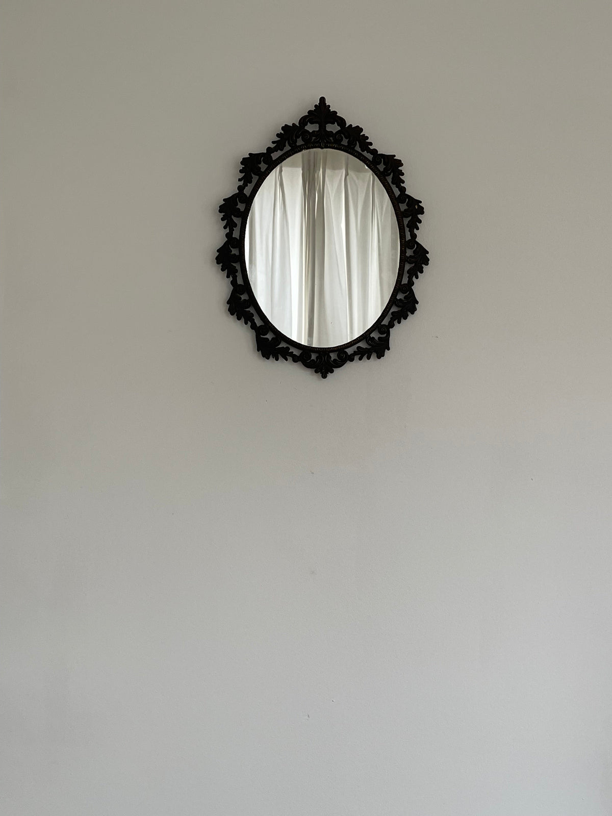 Ornate Vintage Oval Mirror, Rococo Frame — hung on light wall with curtains