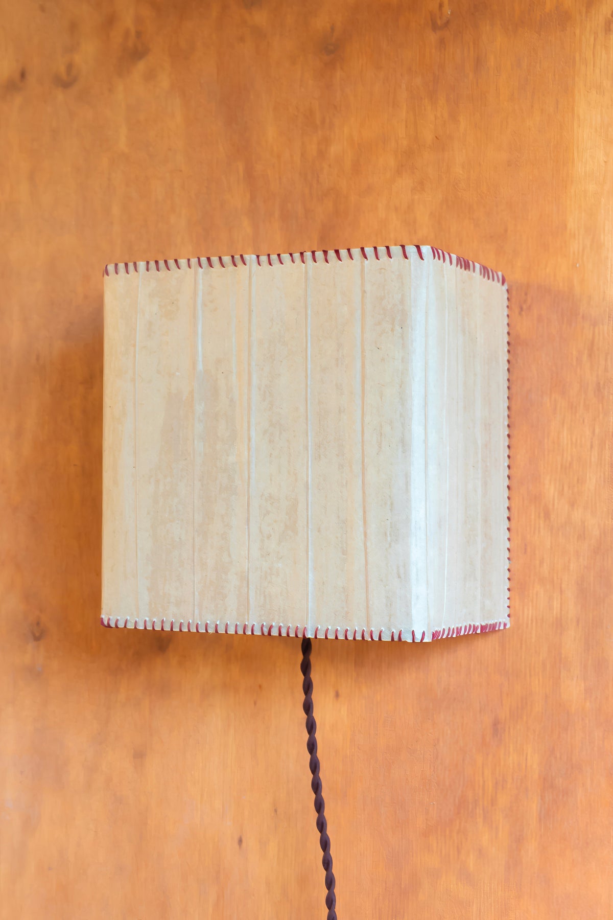 Magdalena Sconce — top view of beige paper shade against wood wall