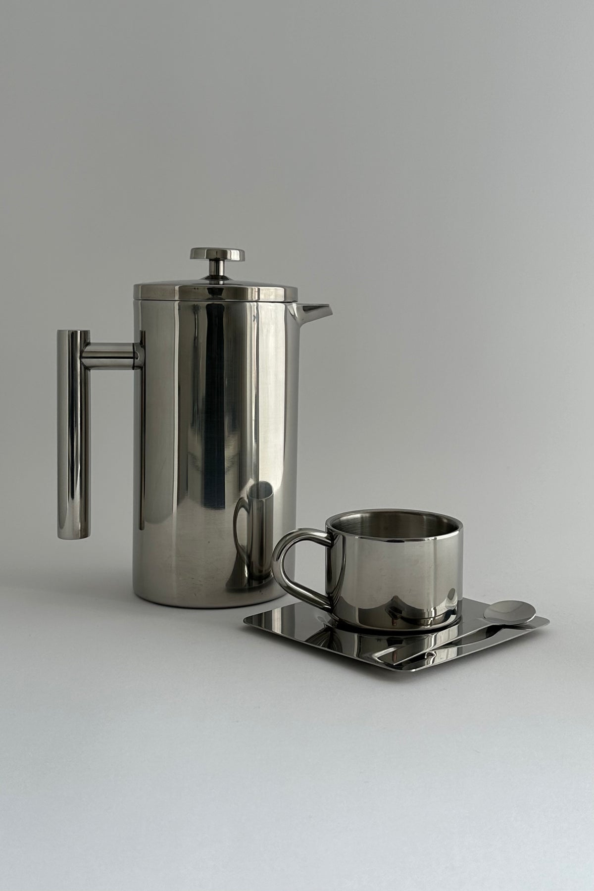 'HEDONISM' stainless steel cup with saucer — lifestyle setting