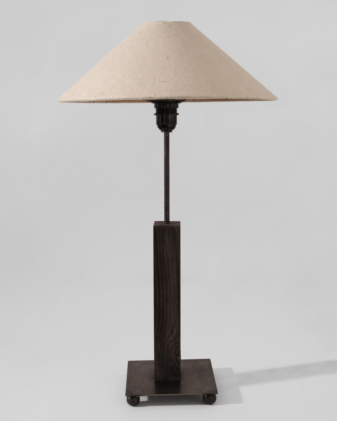 The Mid-Century Swedish Wood And Iron Tall Lamp by Vintage Stories features a beige textured paper shade and dark geometric wooden base, standing on a square platform against a light gray background.
