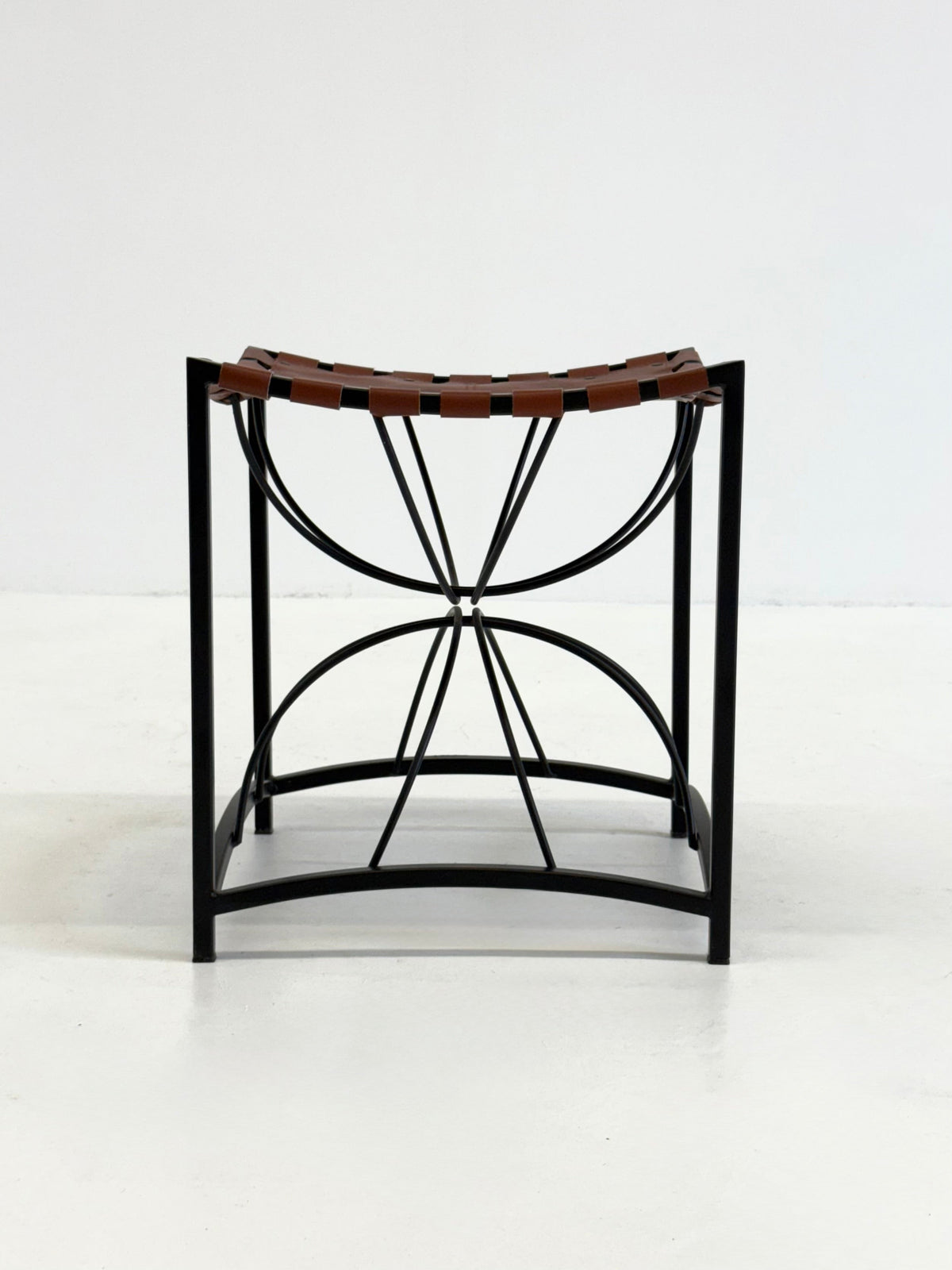 Elegant vintage French stool with black metal and brown leather — detail view