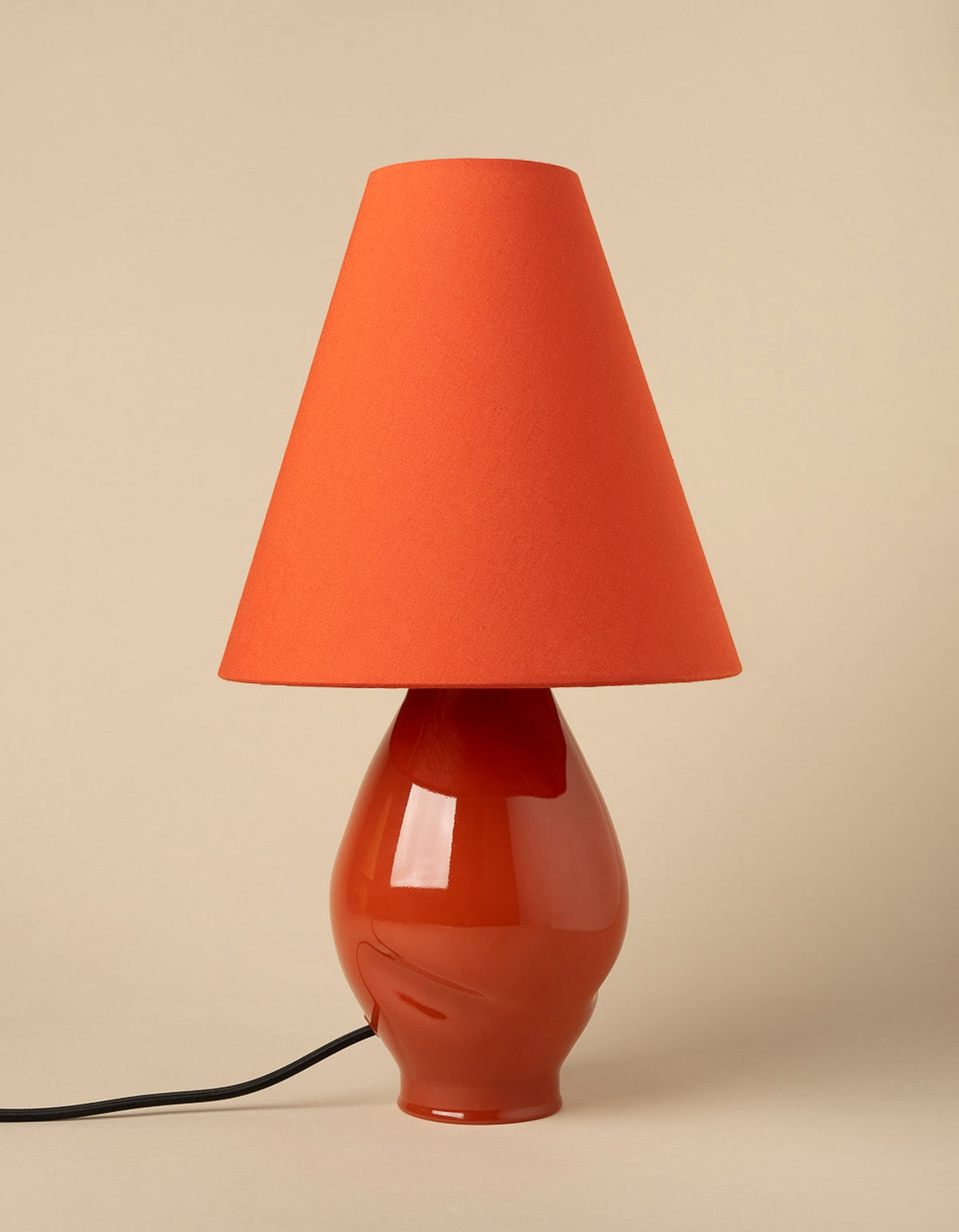 Dark red glazed ceramic table lamp with orange conical shade