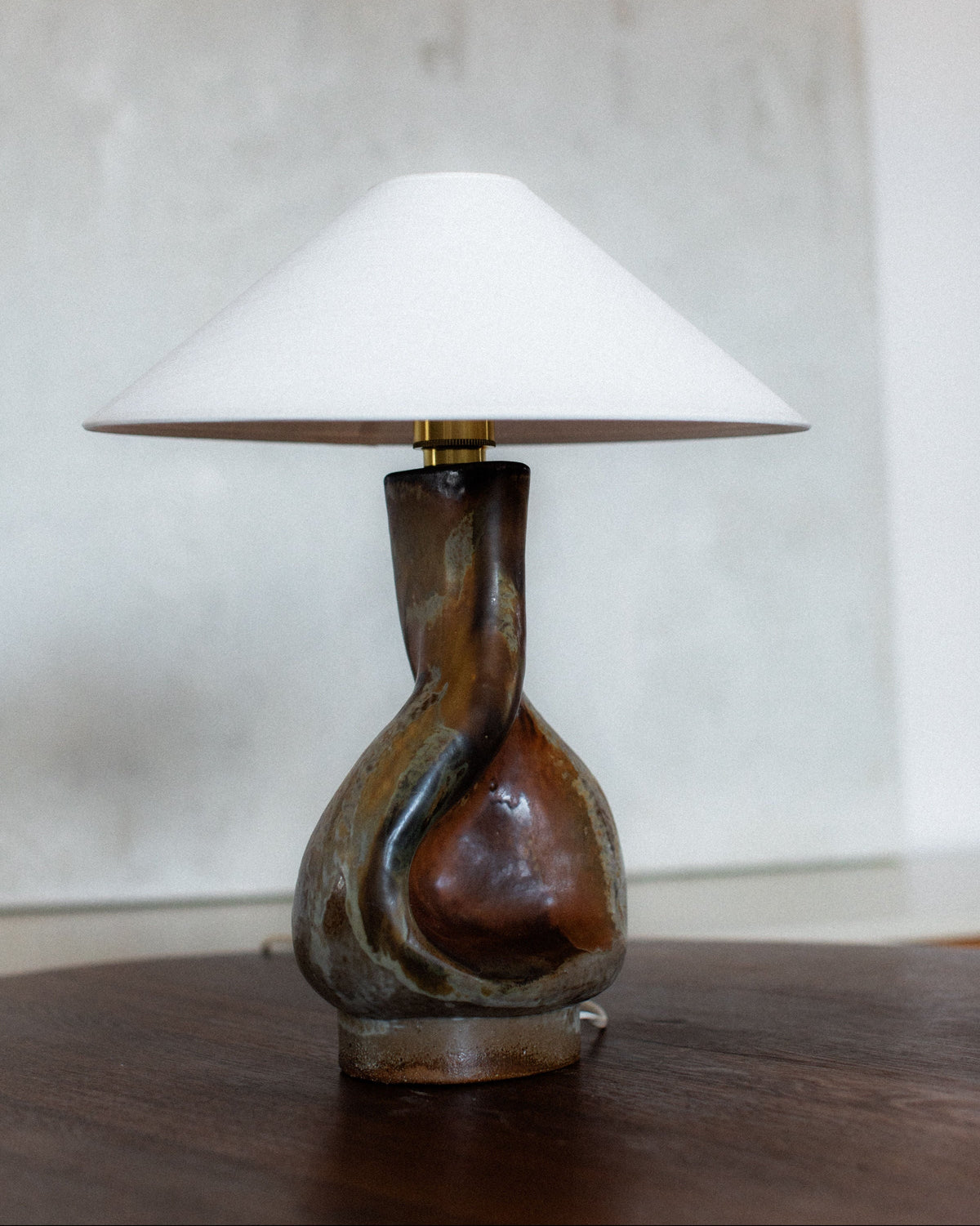 Sculptural ceramic table lamp with organic twisted base and conical shade