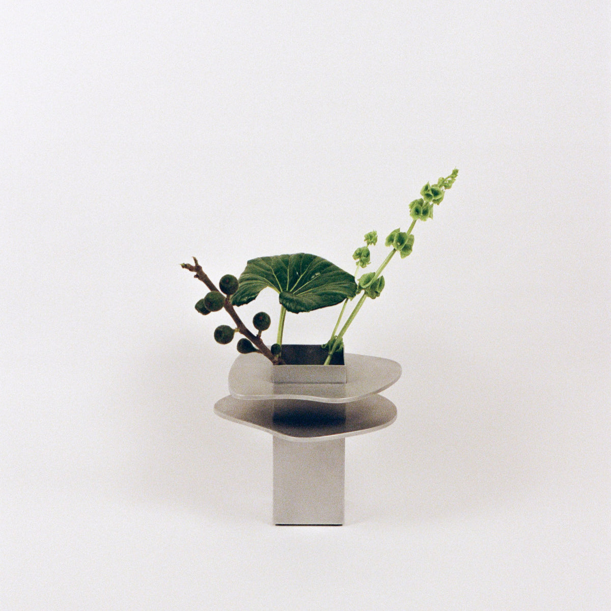 Flange Vase — modern stainless steel vase with greenery