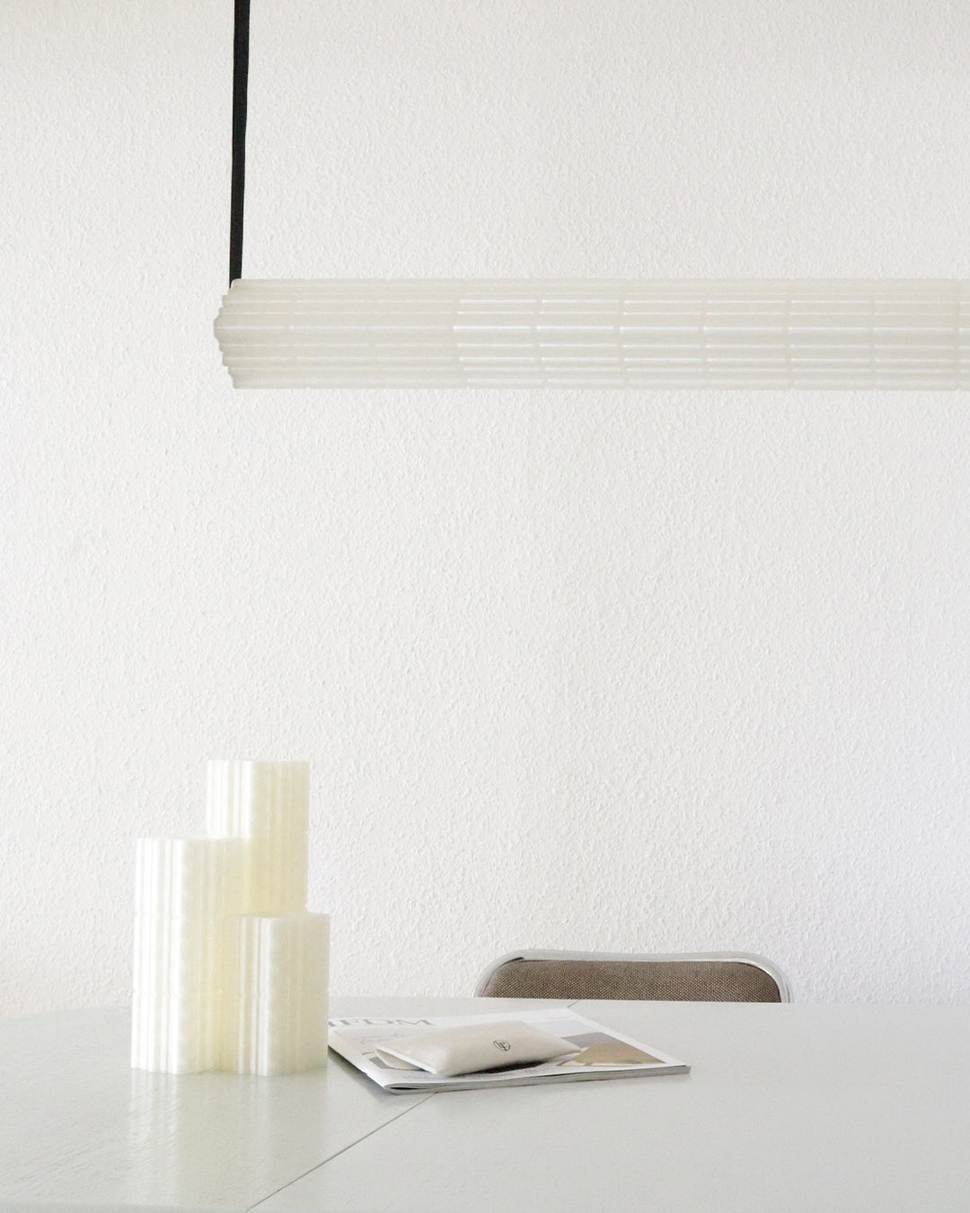 White ribbed cylindrical Goth pendant light in minimalist setting