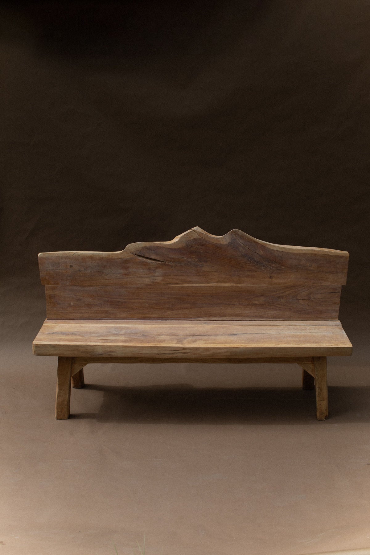 Brutalist wooden bench with carved mountain backrest detail
