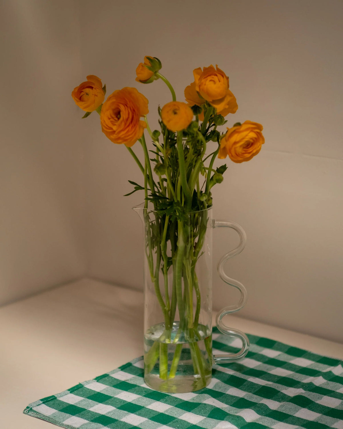 Wave Pitcher — clear glass with yellow flowers on checkered cloth
