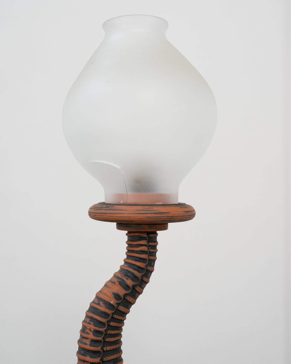 Curved sculptural terracotta lamp stem with frosted glass shade